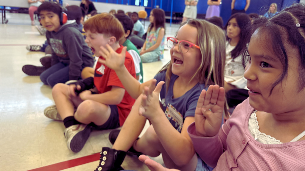 Kids cheers at they find out Thrivent is sending backpacks with reading materials home for the summer.