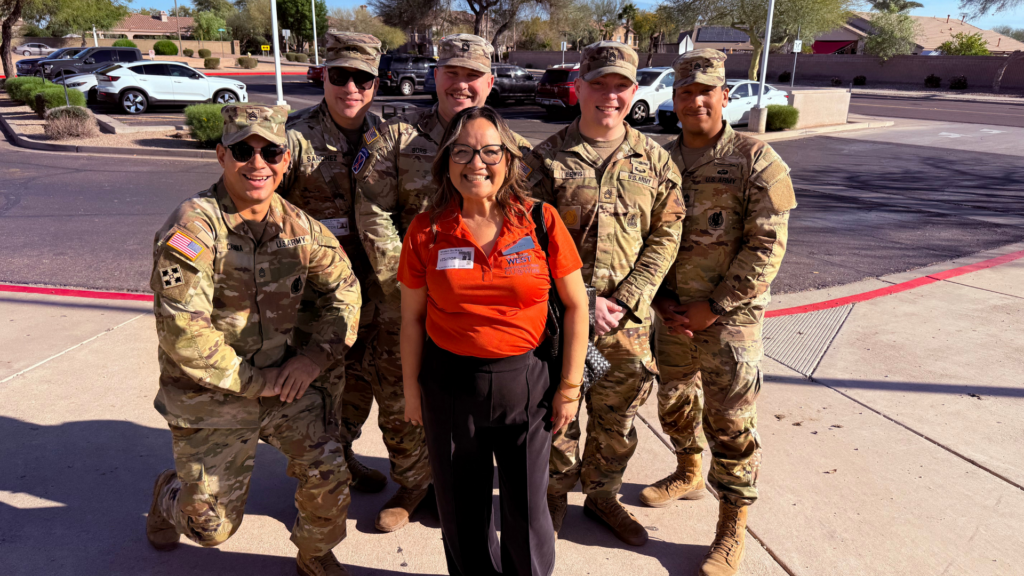 Volunteers from Credit Union West and the US Military talk to students about the importance of school.